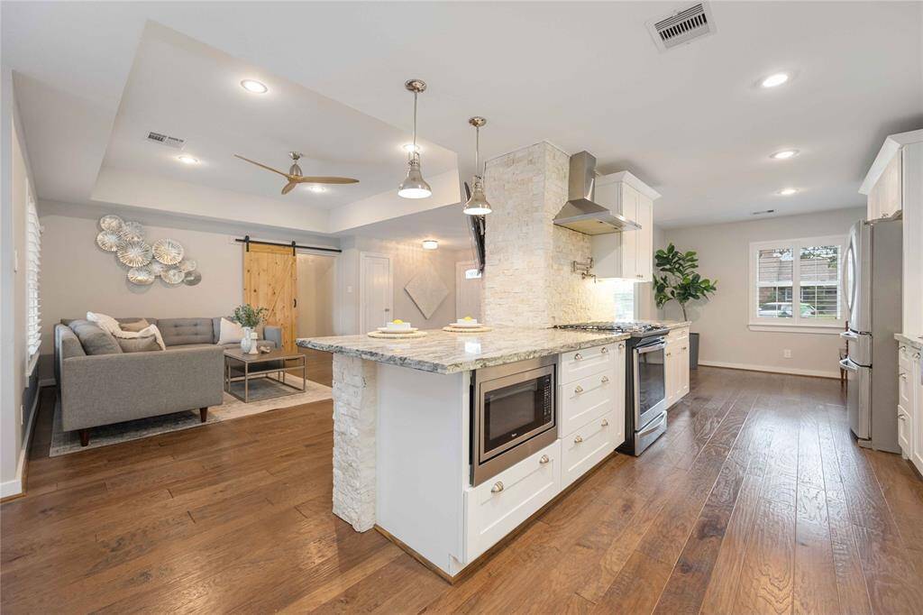 This view accents the tray ceiling in the living room, the wonderfully appointed kitchen, and the entrance to the dining area.