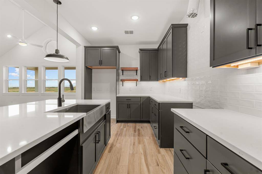 Stylish kitchen with quartz countertops and floating shelves (*Photo not of actual home and used for illustration purposes only.)