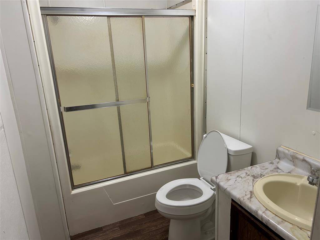 The bathroom has a tub/ Shower and vanity sick