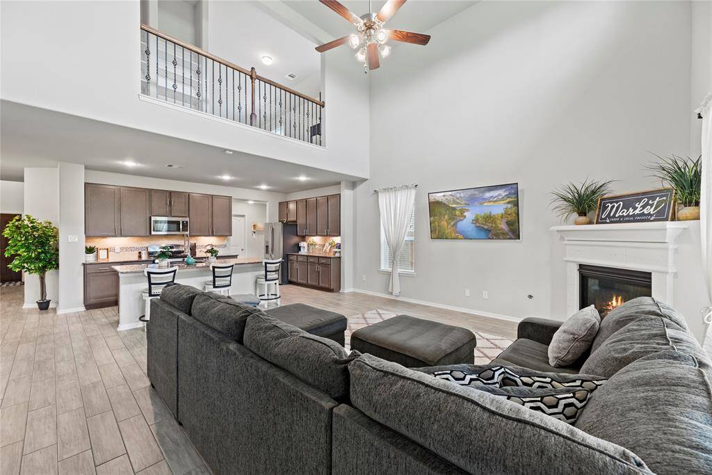 View of the living room and kitchen and balcony above.