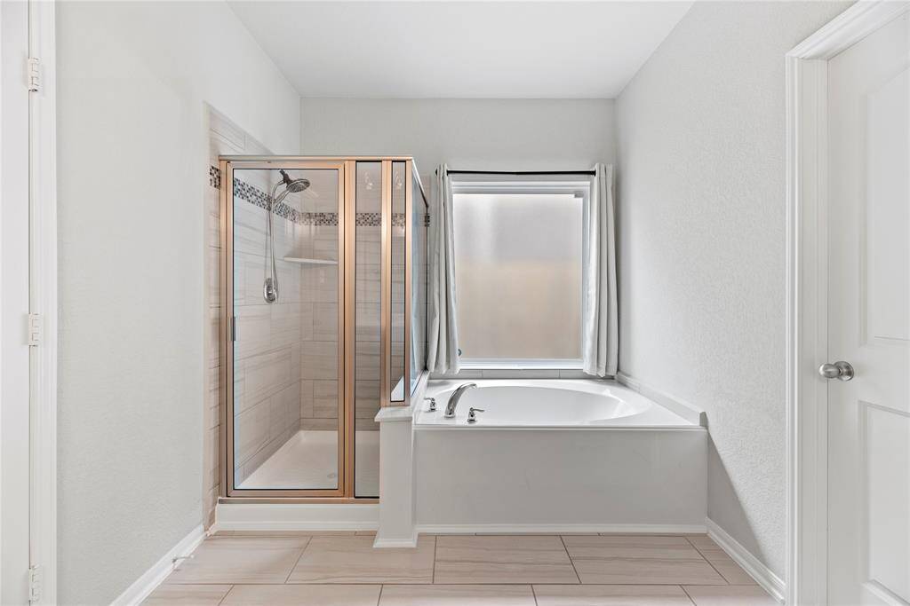 Primary bathroom offers a soaking tub and separate shower.