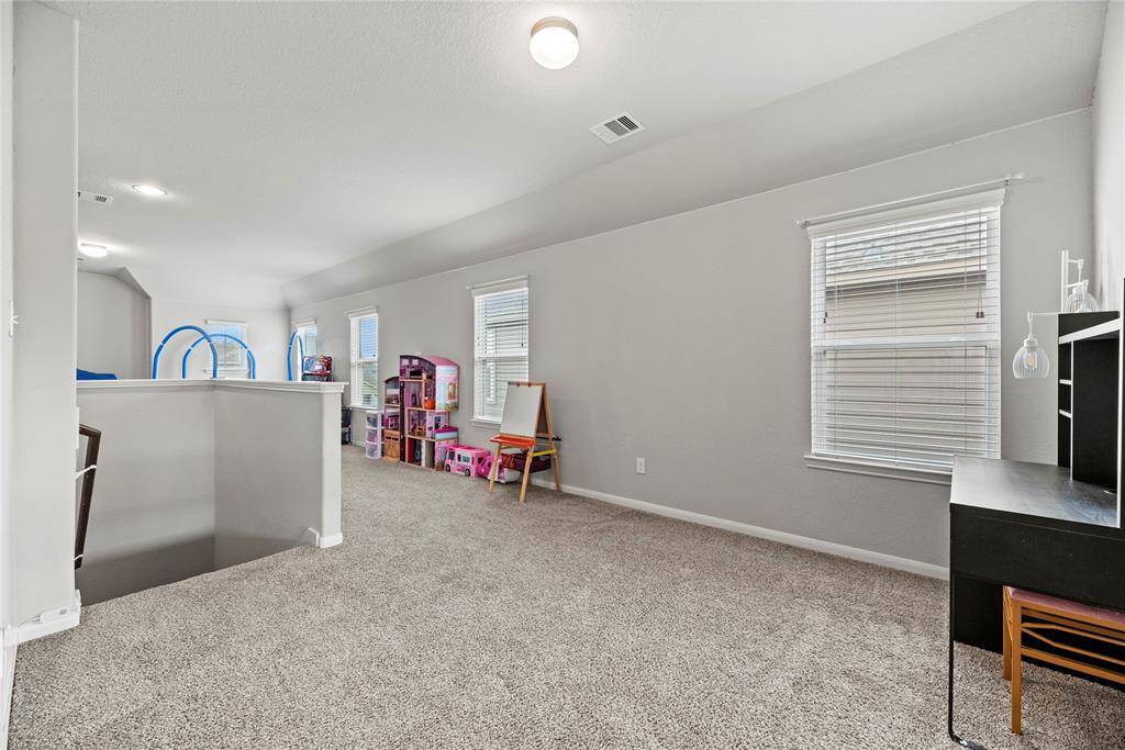 The large, versatile game room at the top of the stairs.