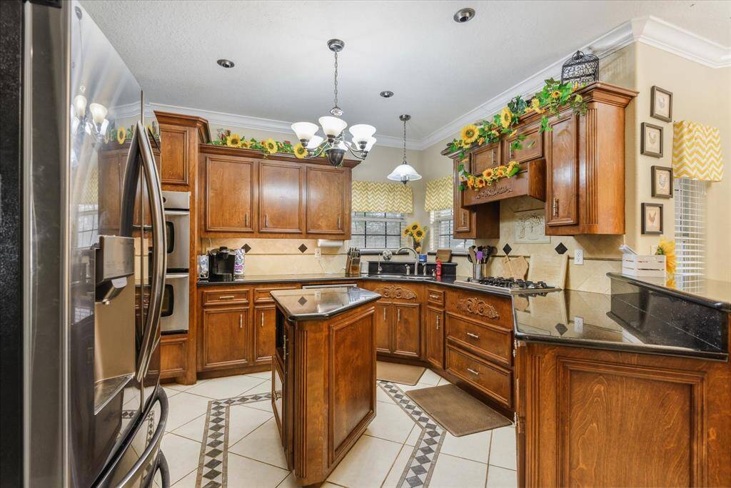 Gourmet kitchen! Stainless steel appliances, double oven, gas cooktop, deep drawers, island with electric, granite counters and a breakfast bar.