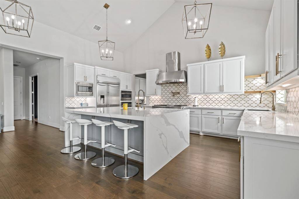 Welcome to the Gourmet Kitchen! This marvelous space features custom backsplash, waterfall edge island, high end appliances and an abundance of cabinet and countertop space!