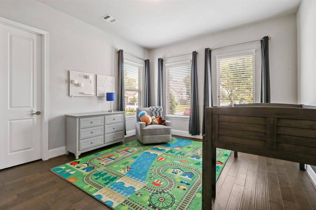 Another splendid secondary bedroom with hardwood floors, ample closet space, and large windows offering views of the beautiful neighborhood.