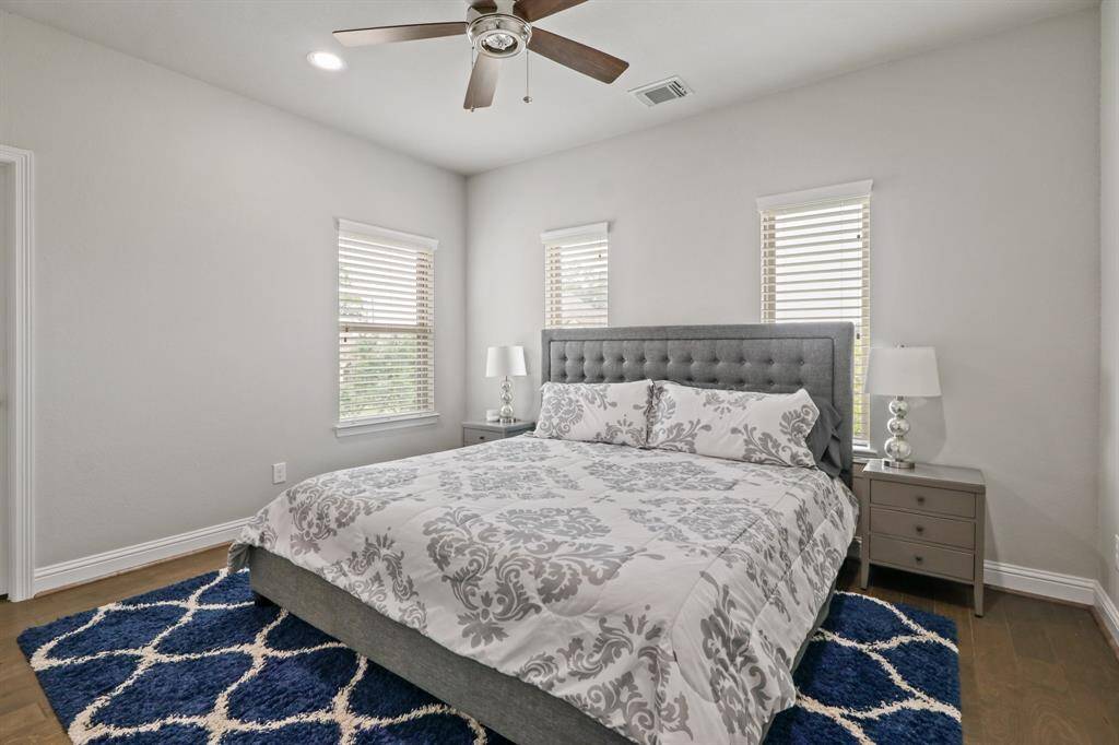 This Spacious Secondary bedroom features handsome hardwood floors, ceiling fan and windows to allow in natural light.
