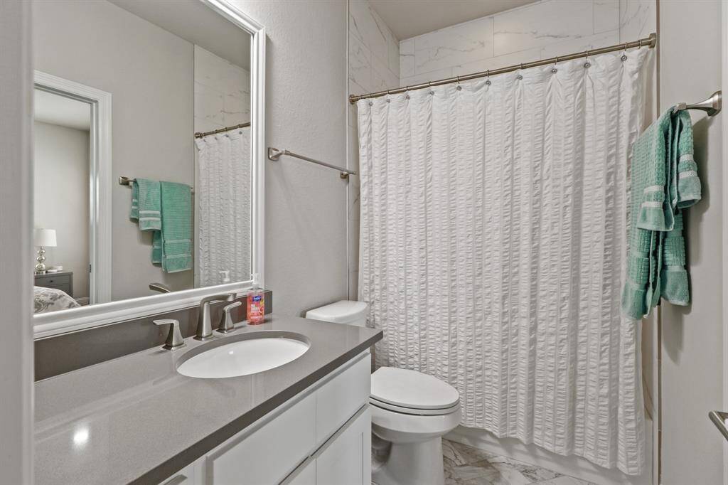Another en suite secondary bathroom features tub/shower combo with tile surround as well as extended sink and mirror, making getting ready in the morning a breeze.