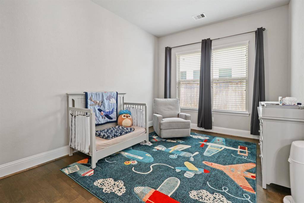 Secondary Bedroom features hardwood flooring and oversized windows to flood the room with natural light.