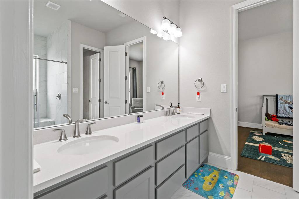 This Jack and Jill bath connects two of the Secondary Bedrooms and features double sinks, granite countertops and glass enclosed tub/shower combo with tile surround.