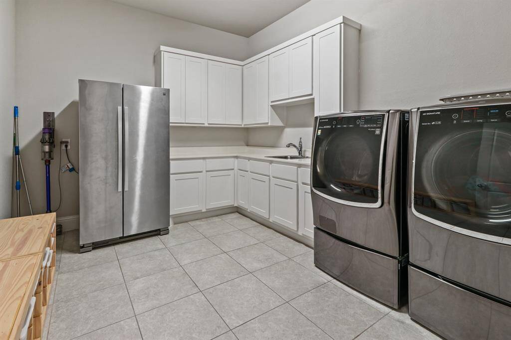 The In House Utility Room offers tile flooring, additional cabinets and countertop space, and room for an additional fridge!