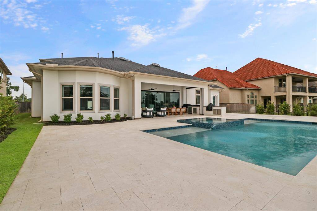 Go for a dip in this sparkling pool or hot tub or enjoy the breezes under the charming covered patio in this Backyard Oasis.
