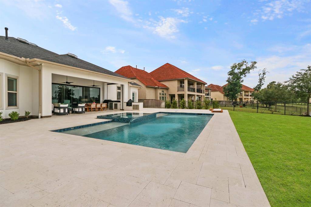 This backyard has it all! Entertain guests under the covered patio, go for a swim in the crystal clear pool or watch the kids or pets run and play on the greenspace, all with Lake Views!