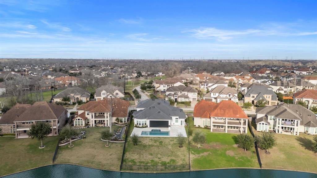 Take in the breathtaking aerial view of this stunning property! From the back of the house, you'll see the expansive backyard, complete with a sparkling pool and spa, all set against the serene backdrop of the lake. This picturesque setting offers the perfect combination of luxury and tranquility—ideal for those who love waterfront living!