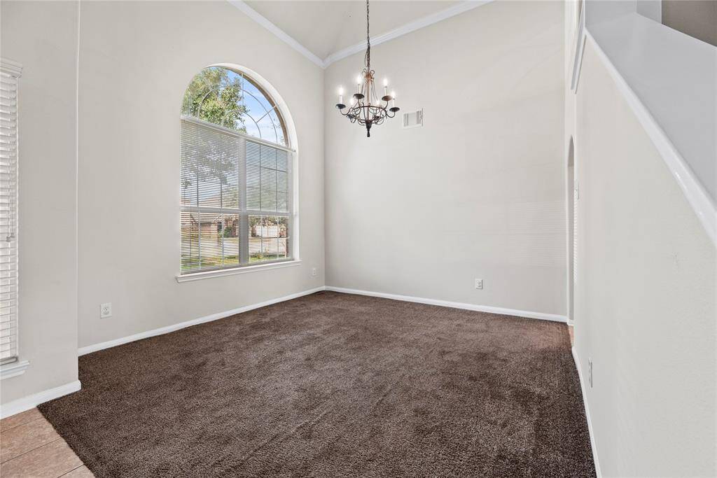 To the left of the entry is your formal dining space. The luxury fixture adds to the upscale atmosphere, with a dazzling chandelier casting a soft, flattering light over the space.