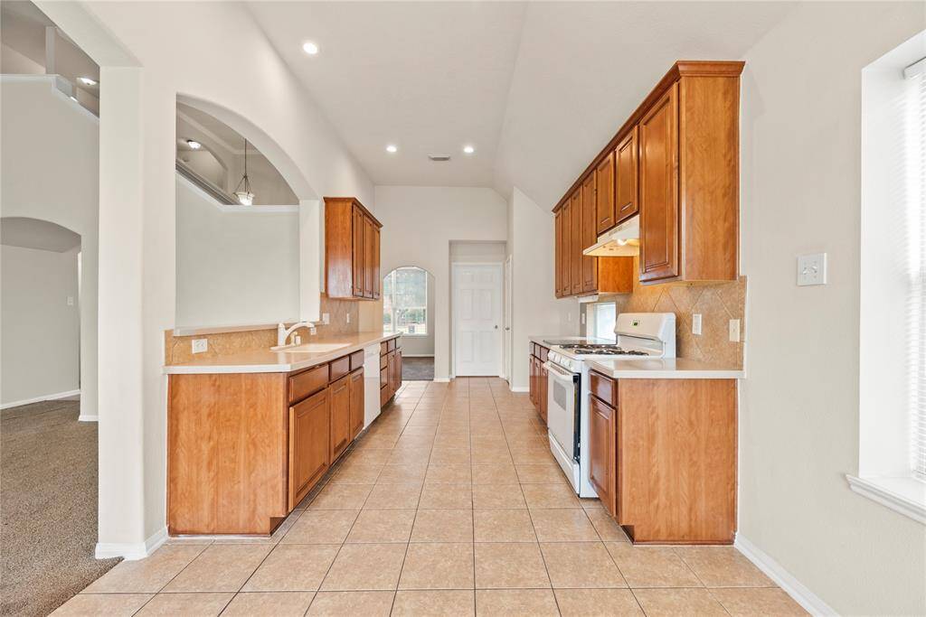 Your chef inspired kitchen awaits! Features include corian countertops paired with a coordinating stone backsplash, high end appliances, rich cabinets and breakfast bar seating.