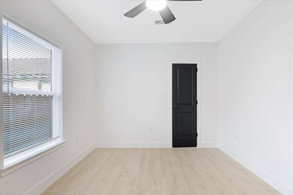 Spacious and bright second bedroom with modern flooring and ample natural light.