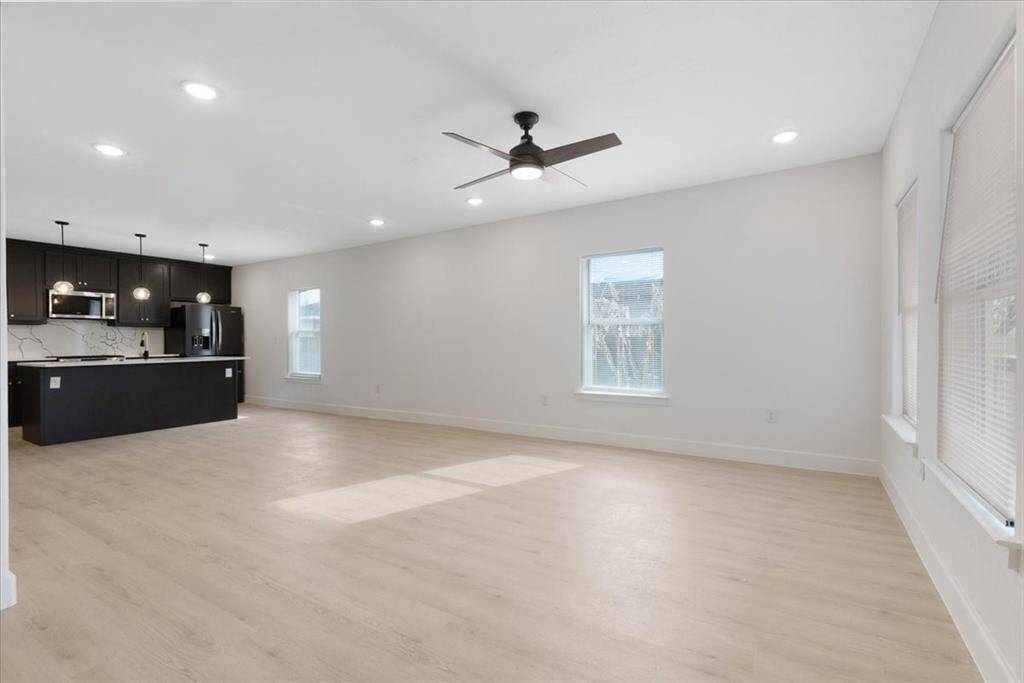 Discover modern elegance at 6609 Avenue Q. This home boasts a sleek kitchen with stylish cabinetry, a central island, and contemporary lighting. Perfect for those seeking a blend of comfort and sophistication.