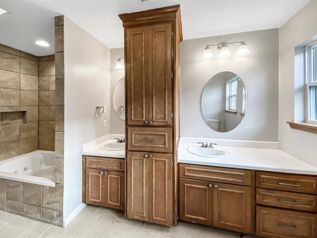 Master bathroom with double sinks and a soaking tub/shower combo.