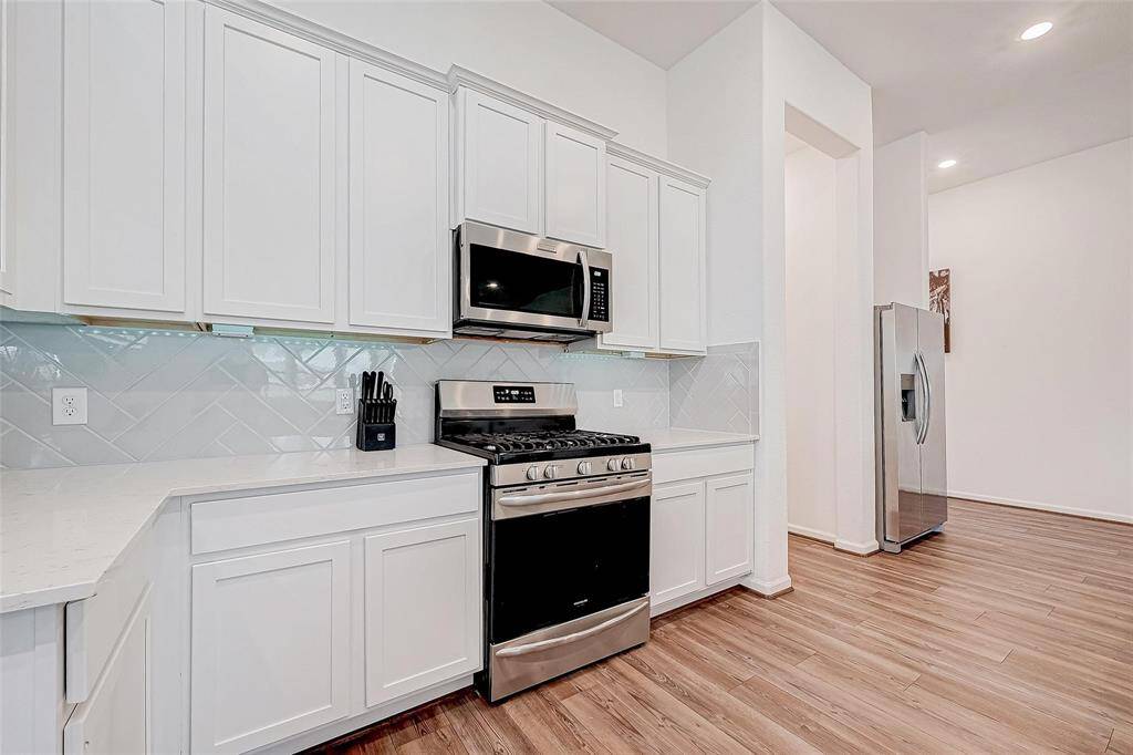 Kitchen features stainless steel appliances, sleek quartz countertops