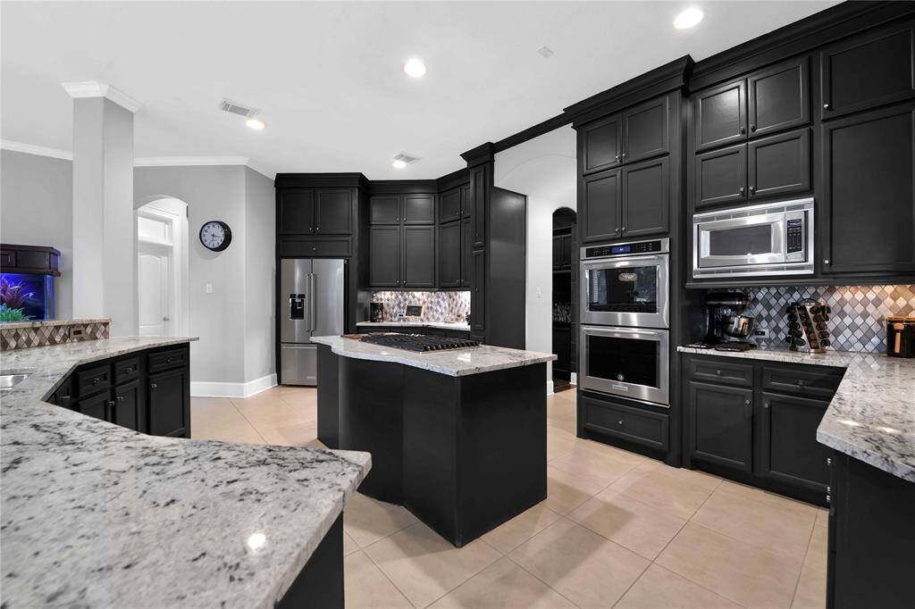 The kitchen is beauOfully complemented by a diamond-shaped backsplash and sleek stainless steel appliances, adding a touch of modern elegance to the space. Under cabinet lighOng conveniently illumunate the workspace!