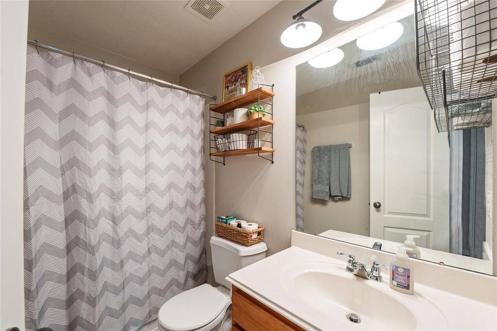 Secondary bathroom with updated light fixture, shower/tub combo and under sink storage. Great space between the second and third bedroom, just off the playroom. Extra storage closet just outside of the door!