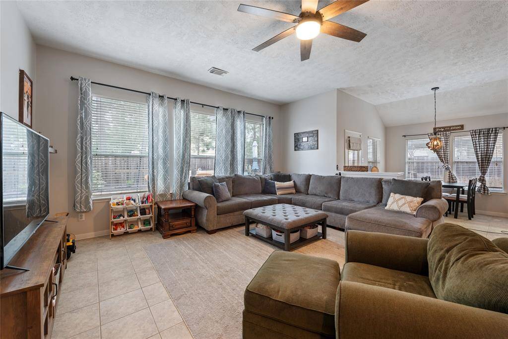 Large living room overlooking the back yard. Large windows and tons of natural light welcome you into this beautiful space to relax! Light fixture recently replaced with remote control!