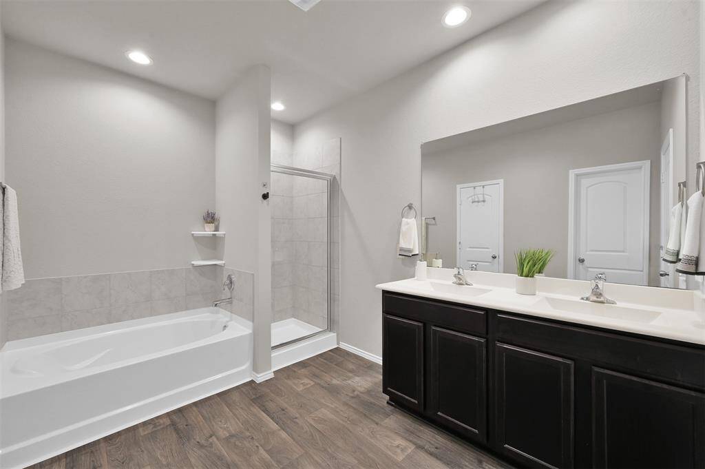 Primary bathroom features two sinks, an oversized walk-in shower, separate tub, and a massive walk-in closet!