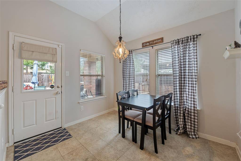 Breakfast room welcomes the natural light to start your day off right! Leading to the laundry room with shelving and backyard!