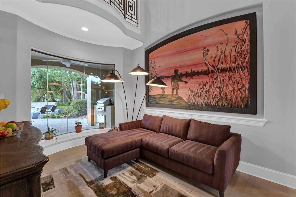 The formal living room offers serene views of the backyard paradise, complemented by soaring ceilings and a spacious art niche. The luxurious space is further enhanced by elegant Ole flooring