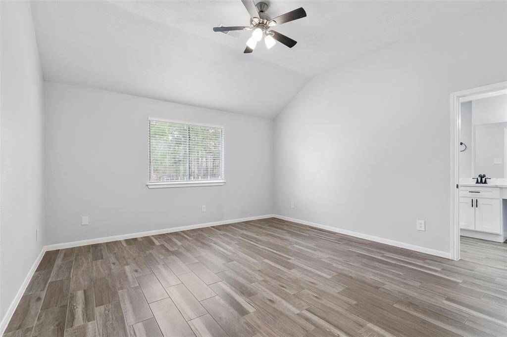 Spacious primary bedroom with a beautiful fan, recent paint and flooring.