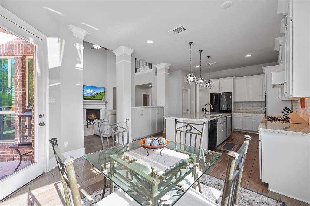 Enjoy breakfast in this bright and inviting eating area. Bathed in natural light from large windows and a glass patio door, this space seamlessly connects to the outdoors, offering effortless access to alfresco dining or morning coffee on the patio.