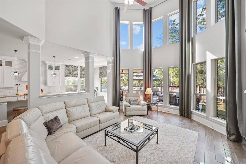 The family room is basked in natural light and offers stunning views which are highlighted by soaring two-story windows that bring the outdoors in.
