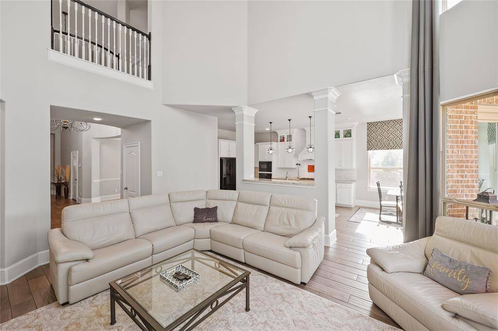 A seamless transition from the living area to the kitchen, emphasizing the open-concept layout. The architectural columns define the boundary between the two spaces without obstructing visibility, allowing for a smooth flow between them.
