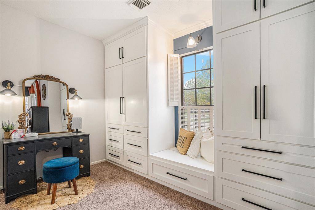Primary bedroom features built-in white cabinetry with ample storage and window seat providing plenty of natural light.