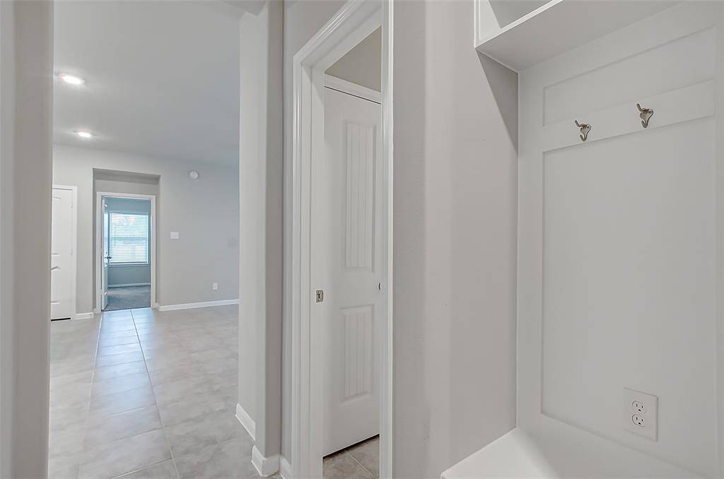Hallway from living room leads to secondary bedrooms and a mud area.