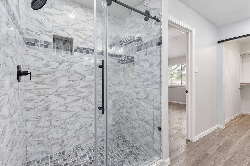 Spacious walk-in closet accessible via a stylish barn door. Vanity area for the Ladies.
