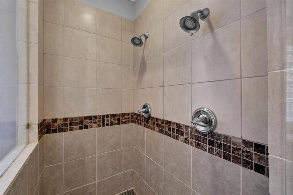 A deep claw-foot soaking tub is gracefully posiOoned on a raised pla?orm beneath a large frosted block window, creaOng the ulOmate space for relaxaOon and tranquility. This elegant feature invites you to unwind in style, enhancing the bathroom's serene ambiance.