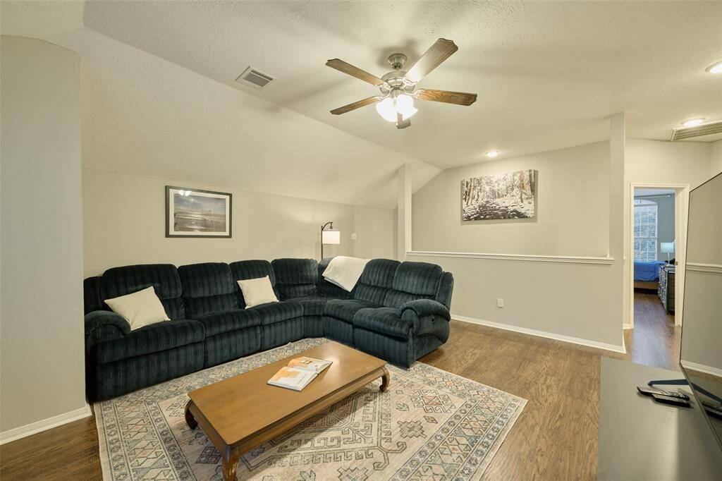 The upstairs living space features high ceilings and ceiling fans. No carpet upstairs.