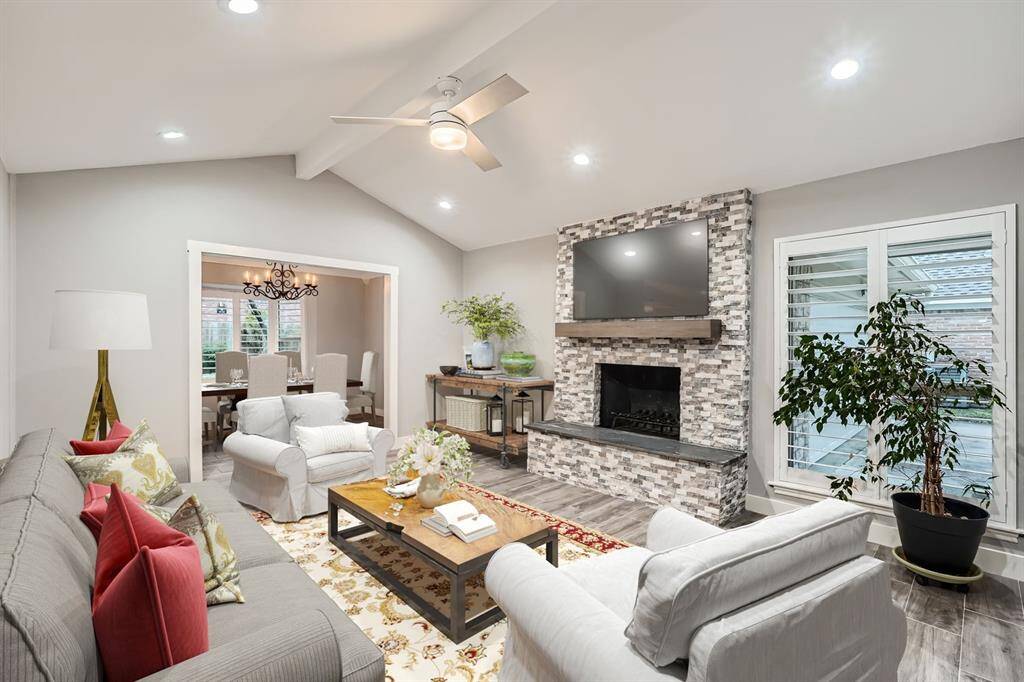 A spacious living room with functioning fireplace opens on to dining room for open floor plan & easy entertaining