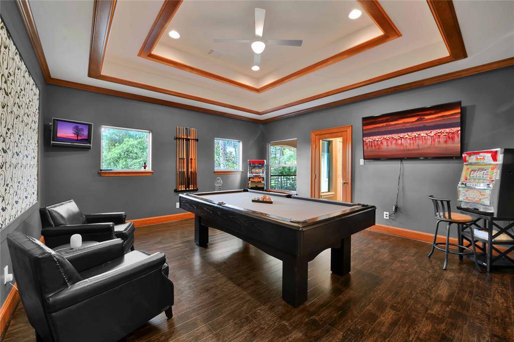 Located off the game room, a spacious balcony overlooks the backyard oasis, providing a perfect vantage point to enjoy serene views or host outdoor events.