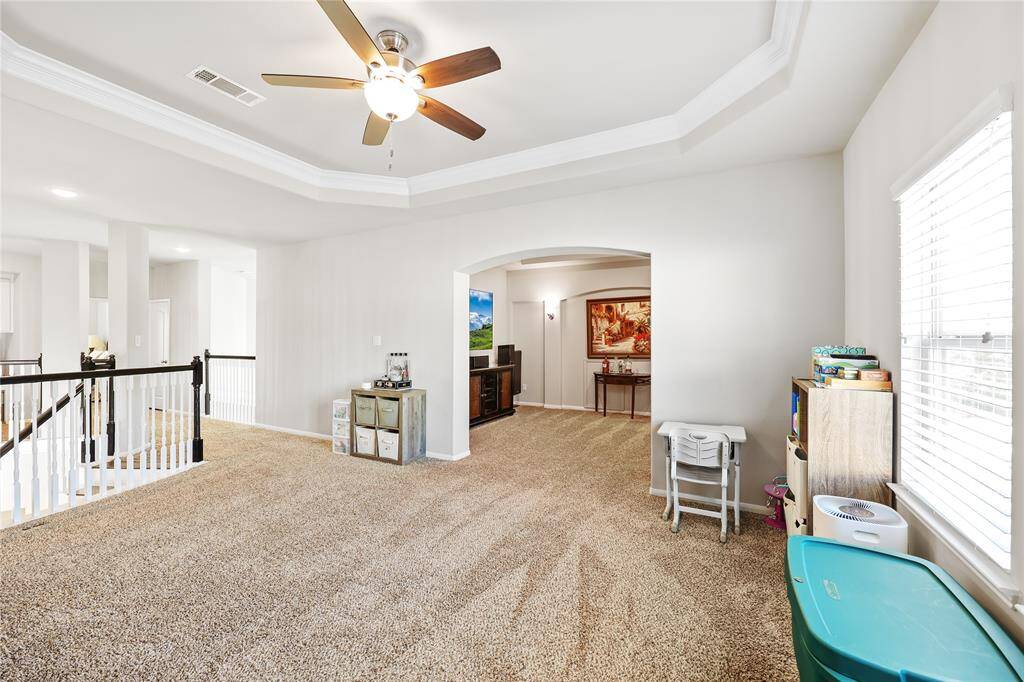 This game room seamlessly transitions into the media room through a wide arched entryway, creating an open yet defined flow between the two spaces