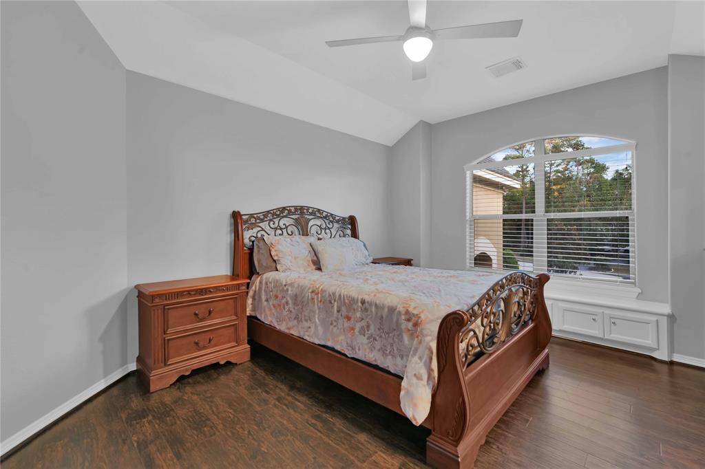 This spacious secondary bathroom features a vanity with a large framed mirror and overhead vanity lighOng. A built-in cabinet above the toilet provides addiOonal storage. The versaOle tub and shower combo offers an ideal space for both bathing and showering, enhancing the bathroom's funcOonality.