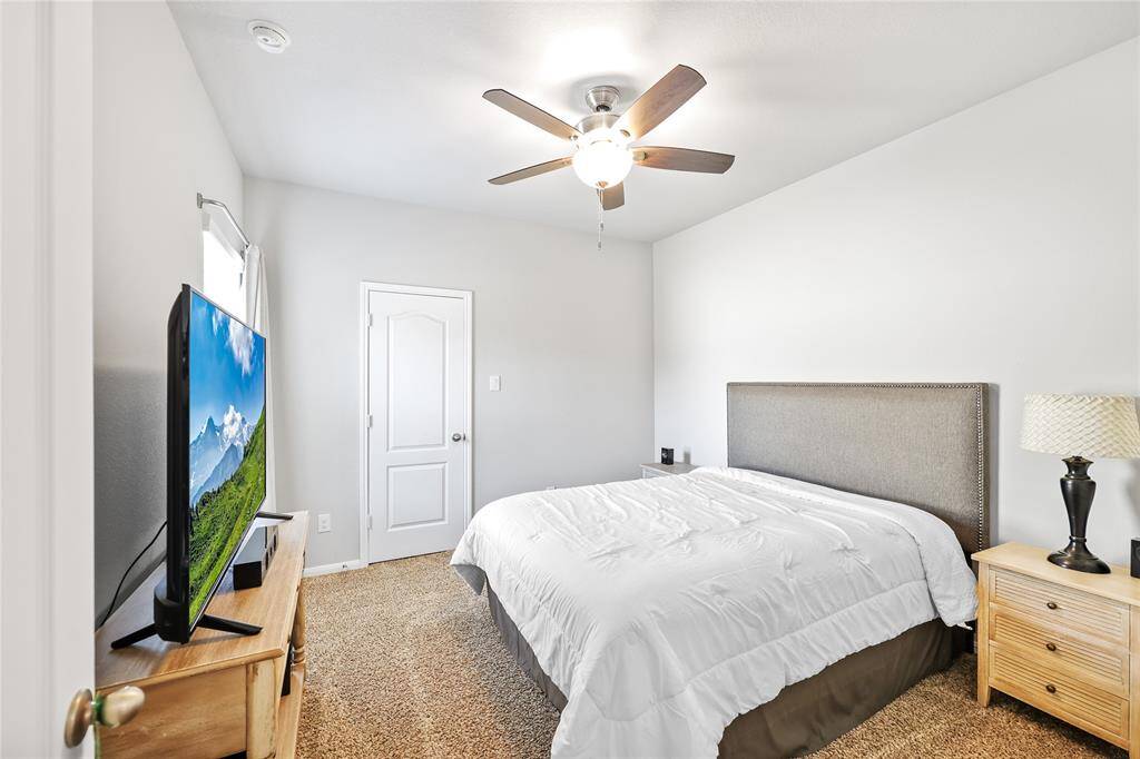 The fourth upstairs bedroom features the same neutral paint and carpeting with a walk in closet