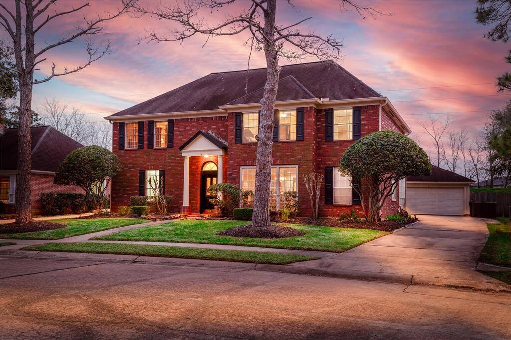 Elegant Home with a Well-maintained Front Yard, Framed by Mature Trees.