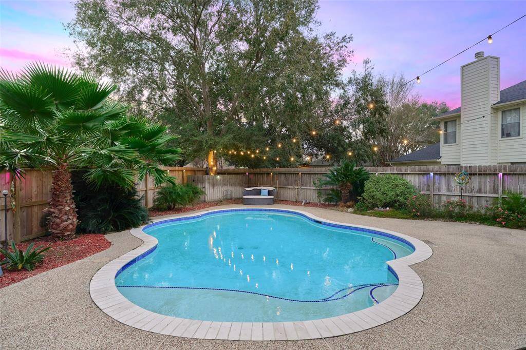 The property features a gunite, in-ground pool with a great view of the sunset and mature landscaping.