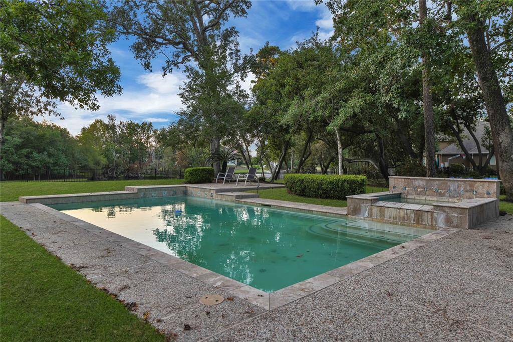 A tranquil spa offers the ideal sanctuary for relaxaOon aOer a long day, providing a peaceful space to unwind and rejuvenate. Towering trees dot the expansive lot, enhancing the serene ambiance.