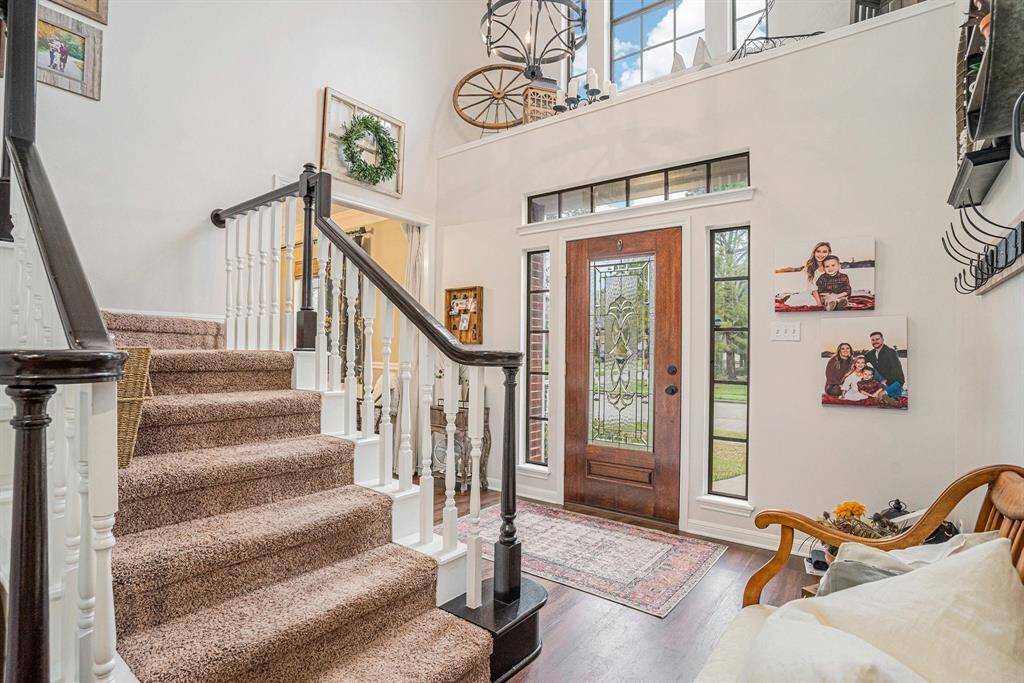 This inviting entryway features a grand staircase with high ceilings with lots of natural light.
