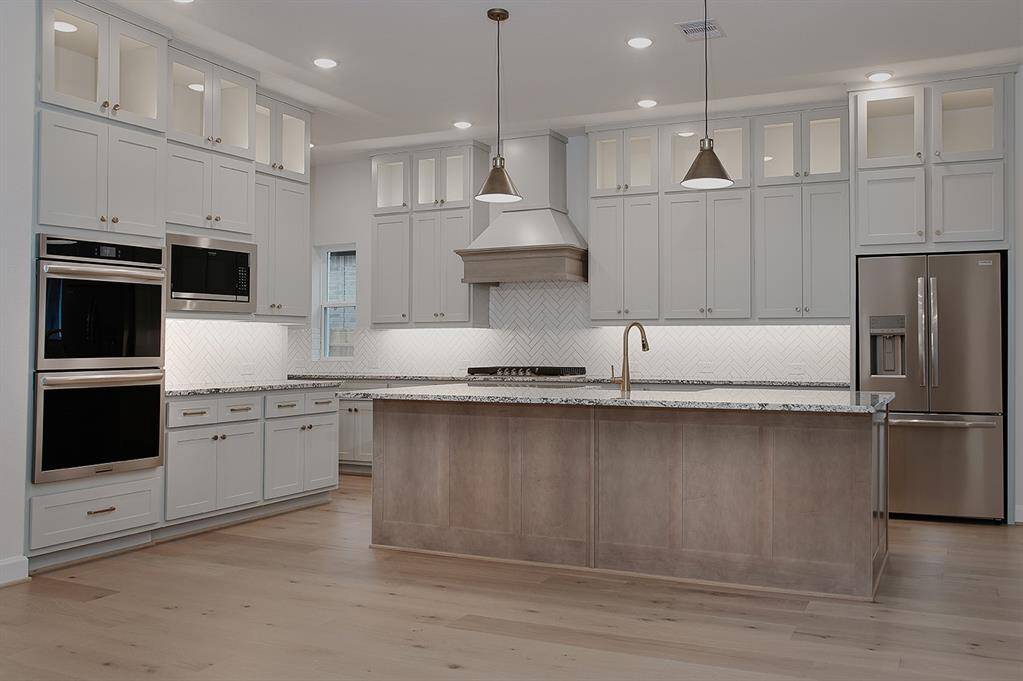 Sprawling kitchen with upgraded appliances, cabinetry, lighting and plumbing fixtures