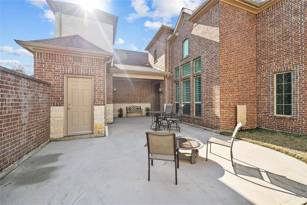 This stunning private courtyard, surrounded by beautiful brick walls and accented with stone details, is an inviting outdoor space providing a serene retreat for relaxation and entertaining. The spacious concrete patio provides room for ample seating areas, ideal for enjoying the outdoors. An additional room for storage is another great feature of this space.