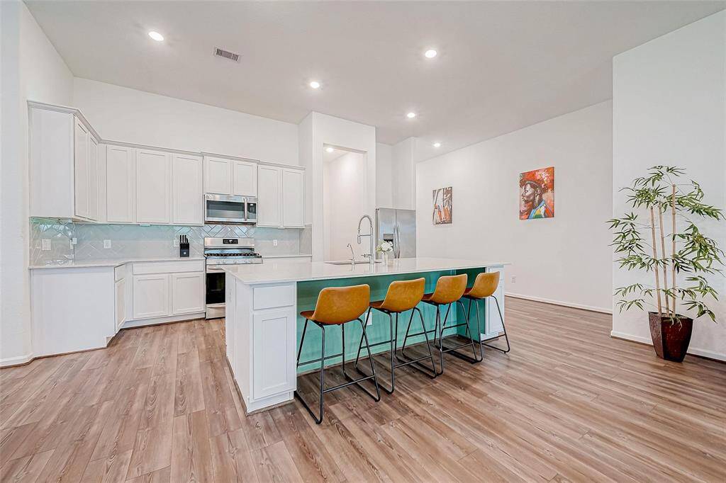 Kitchen features stainless steel appliances, sleek quartz countertops